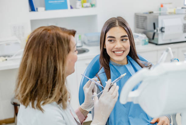 istock Female dentist talking with patient 1339107556