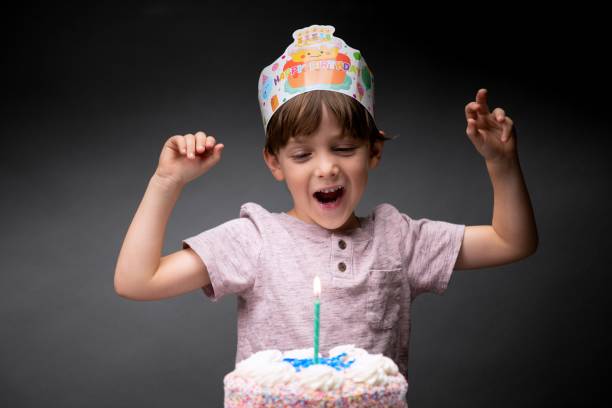 istock Happy little boy posing with his birthday cake 1339109518