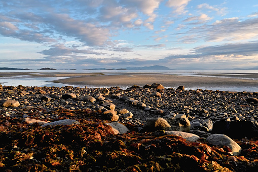 A well created footpath leading during low tide directly to the sandbar is featured in this capture surrounded by small stones and boulder - rocks in the early hours of this morning under a mixture of sun and clouds.