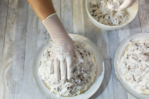 istock Cake making process. Female hands in culinary gloves form a chocolate cake with sour cream. Step by step recipe for chocolate cake. Series. Baking concept. 1339113696