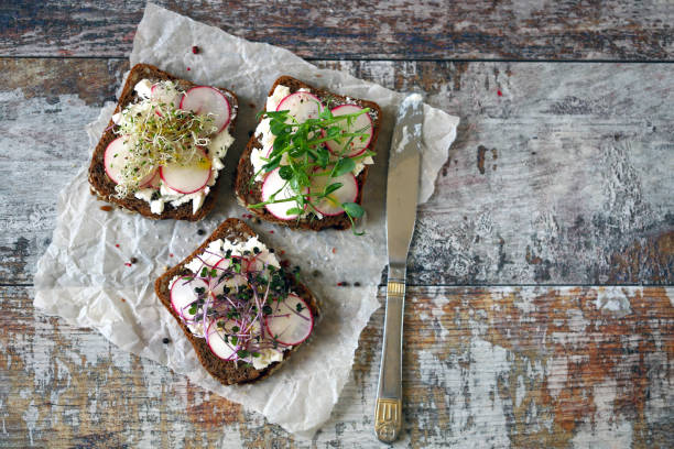 Open sandwiches with white cheese, radish and microgreens. stock photo