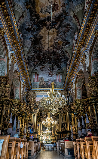 Lviv , Ukraine - September 06, 2021: majestic luxurious interior and people who came to the evening prayer at the Church of St. Andrew the First-Called in Lviv. Gothic church and Bernardine monastery, modern Greek Catholic church
