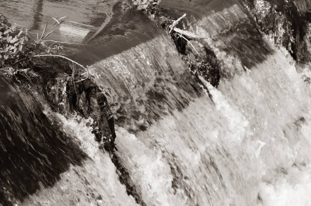 istock Water flowing over a river weir 1339124704