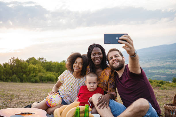 istock Multi racial family with child taking selfie at park 1339126054
