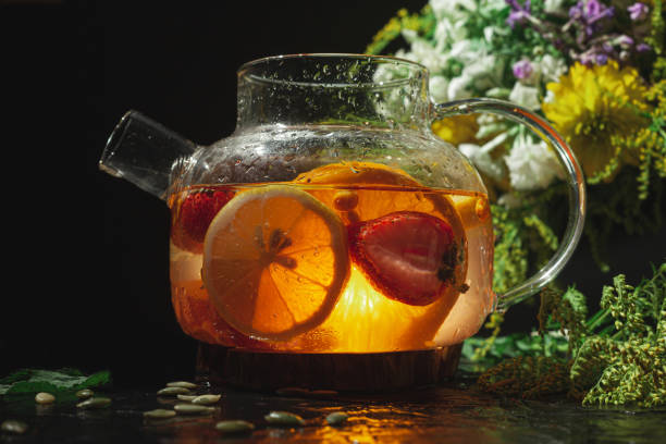 istock Bright transparent glass teapot with fruit. Sunlight through the glass 1339126141