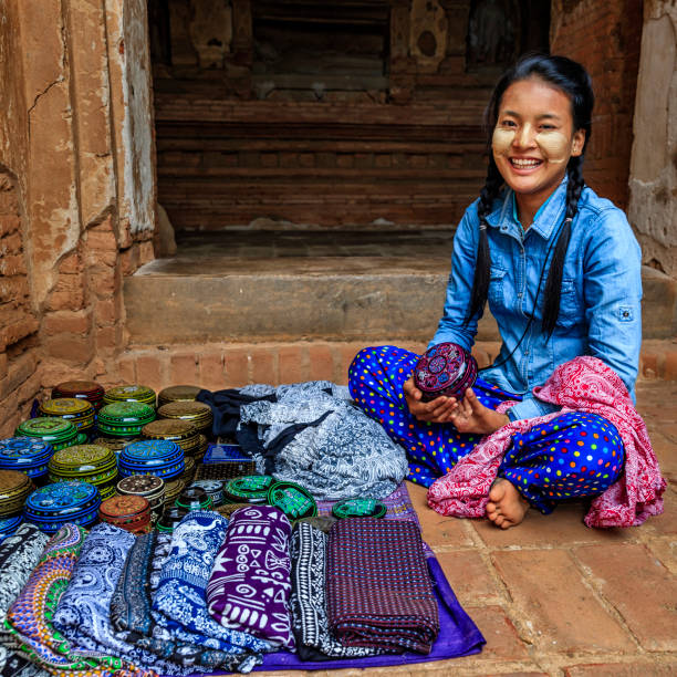 Young Burmese girl with thanaka face paint selling souvenirs in the ancient temple of Bagan, Myanmar (Burma)