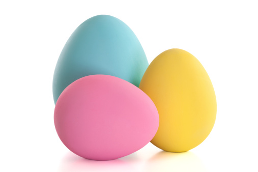 Three large craft easter eggs in blue, pink and yellow isolated on white.