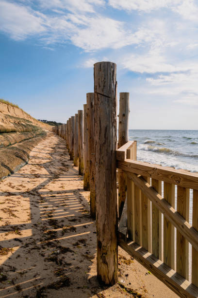 istock Erosion control with giant metallic sand tubes and boarded posts under coastal sand dunes. The backdrop for severe weather, climate change, rising water, and erosion control themes. 1339147671