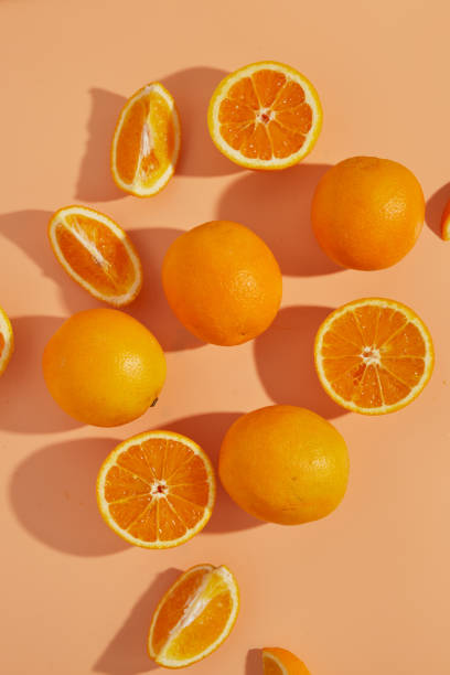 istock Sliced and halved oranges background on orange backdrop 1339152781