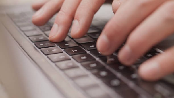 istock Close up macro of hands typing on laptop keyboard mac computer 1339160218