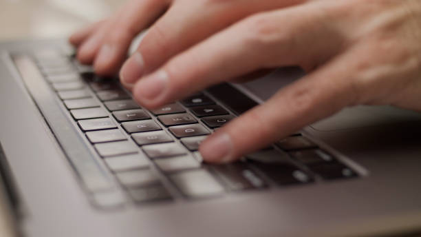 istock Close up macro of hands typing on laptop keyboard mac computer 1339160223