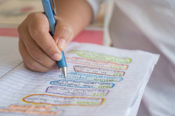 istock Hands student writing and testing English language in exercise, taking fill in notebook exam at school test room, evaluation measurement in education 1339164122