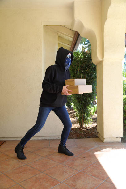 istock Porch Pirate Person in Glasses Steals Boxes Vertical 1339164217