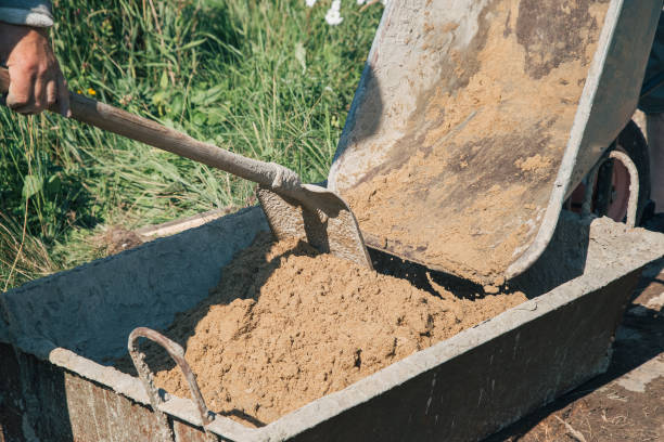 istock Uploading sand into a cement mixture for pouring a garden path 1339167224