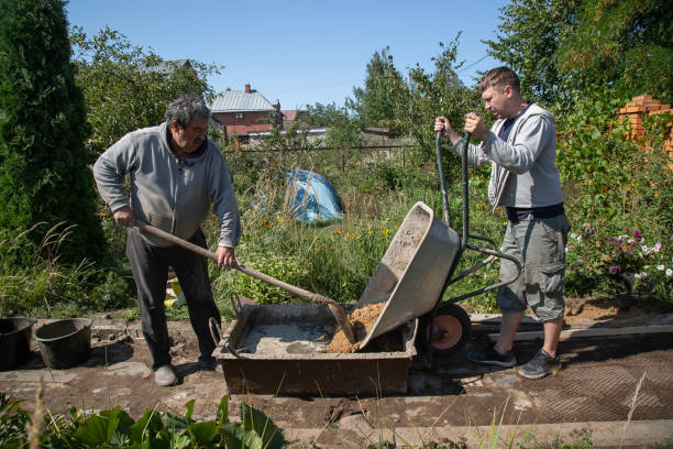 istock A man unloads sand into a cement mixture for pouring a garden path 1339167250