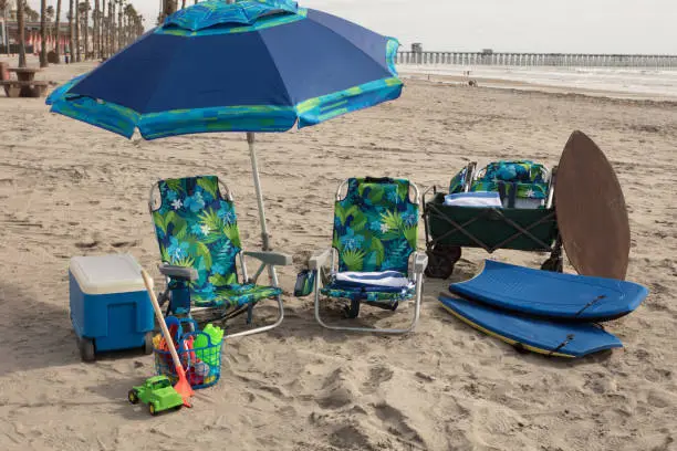 Beach equipment in green and blue with no people. All set up in the summer at the beach.