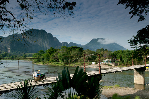 Motorcycle transport on a bridge in Vang Vieng, Laos.