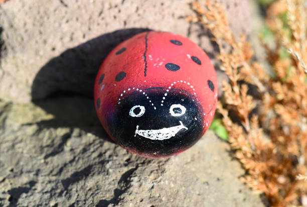 istock Sea ​​stone painted like a ladybug. Decoration for a garden. 1339169439