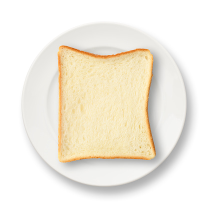 Overhead shot of slice white bread on a white plate, on a white background.