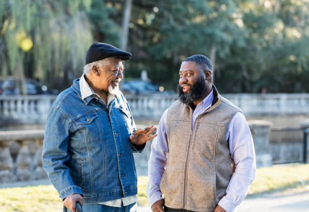 istock Senior African-American man and son at park, talking 1339170435