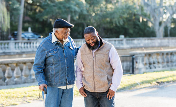 istock Senior African-American man and son at park, talking 1339170449