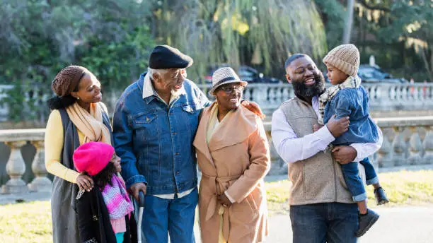 Photo of Three generation African-American family standing in park