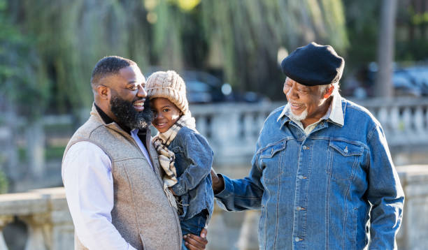 istock Three generation African-American family walking in park 1339170494