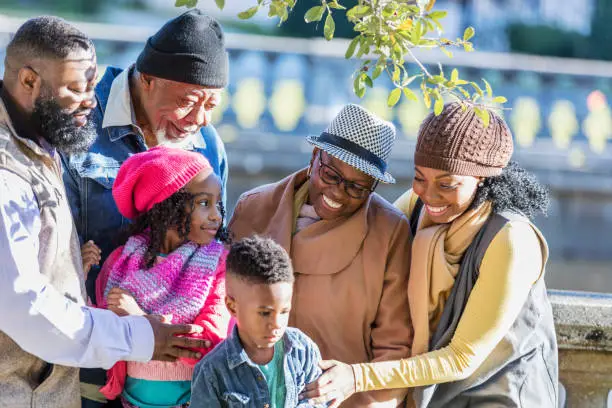 Photo of Three generation African-American family, boy sulking