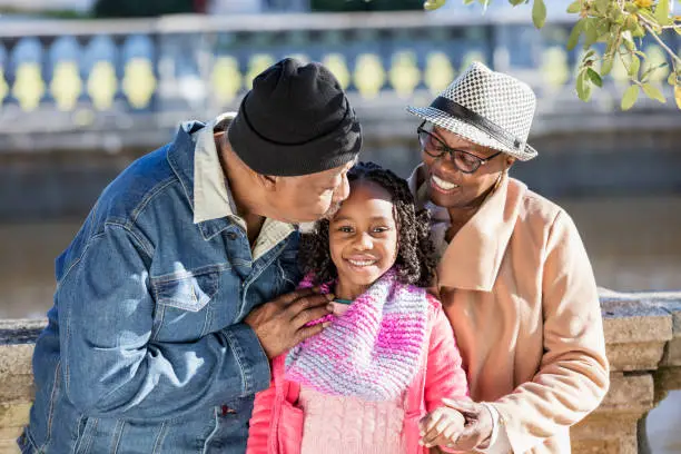 Photo of African-American grandparents, granddaughter at park