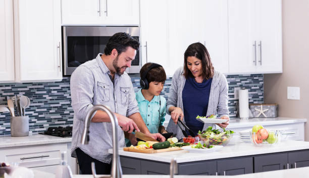 istock Multiracial family in kitchen, making and serving salad 1339171711