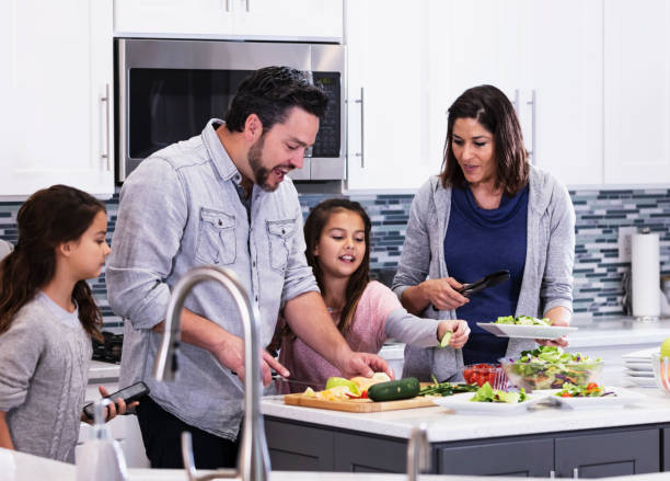 istock Multiracial family in kitchen, making and serving salad 1339171716