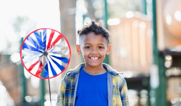 istock Multiracial boy on playground playing with pinwheel 1339173270