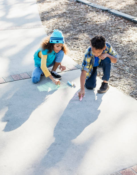 hermanos multirraciales dibujando con tiza en la acera - little girls sidewalk child chalk fotografías e imágenes de stock