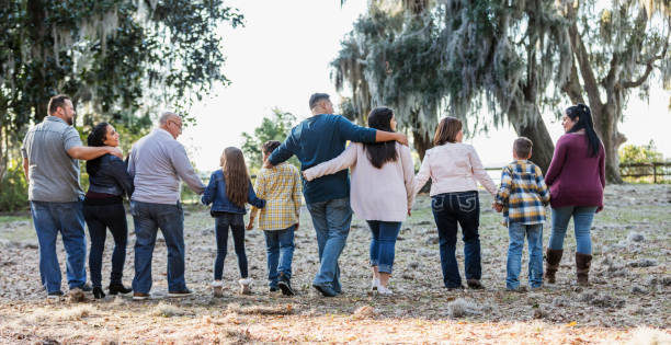 widok z tyłu wielopokoleniowej latynoskiej rodziny spacerującej - large family zdjęcia i obrazy z banku zdjęć