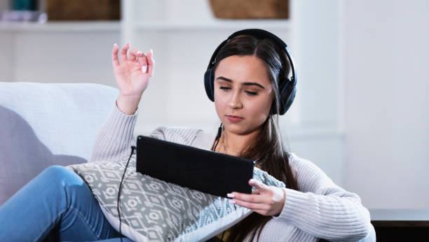 istock Multiracial woman with headphones using digital tablet 1339174125