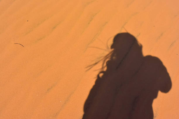 istock Background shadow of girl on sand 1339174857