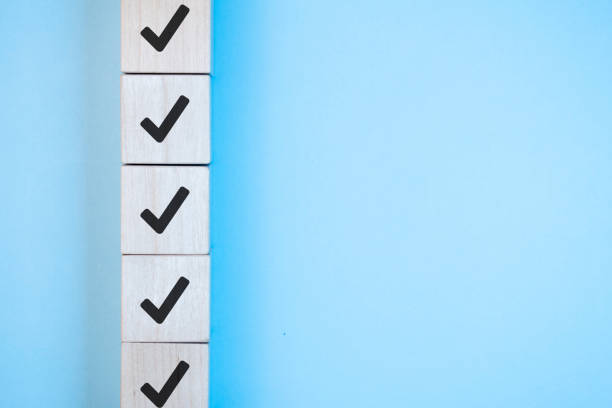 istock Wood cube with check mark on blue background, Checklist concept, Copy space. 1339182418