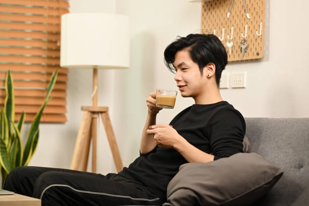 istock Casual man sitting on comfortable sofa and drinking coffee. 1339187964