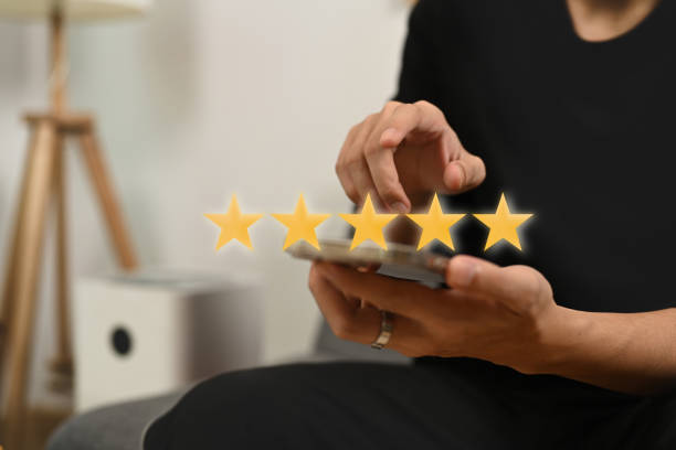 istock Young man pressing on smartphone screen giving positive feedback with gold five star rating. 1339188014
