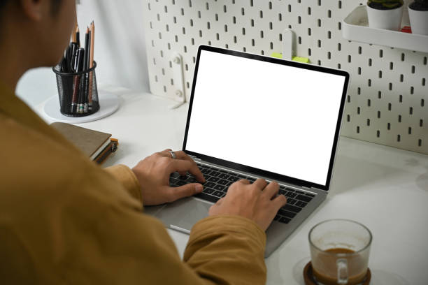 istock View through businessman shoulder working with laptop computer. 1339188017