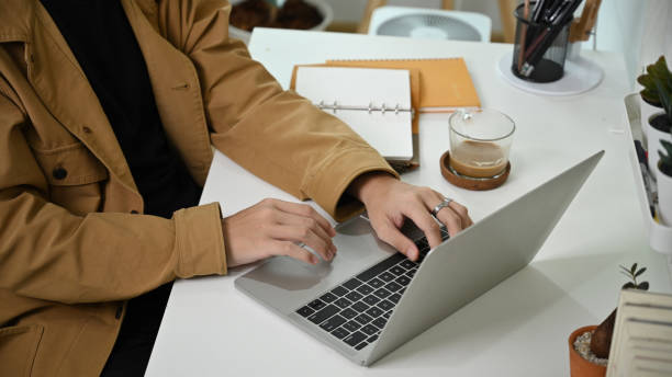 istock Cropped shot man sitting at home office desk and working with laptop computer. 1339188031