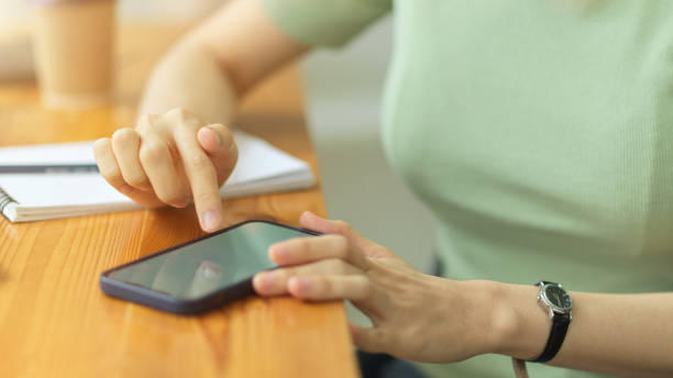 istock Close up, young woman using smartphone, touching mobile screen, surfing internet 1339188894