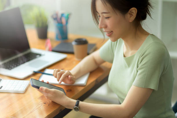 istock Side view, Casual businesswoman using smartphone on working desk in office 1339188897