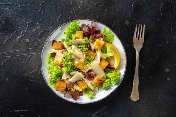 istock Chicken Caesar salad, shot from the top on a black background 1339189612
