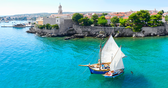 Classic sailboats anchored in front of the Old Town of Krk, Krk Island, Croatia
