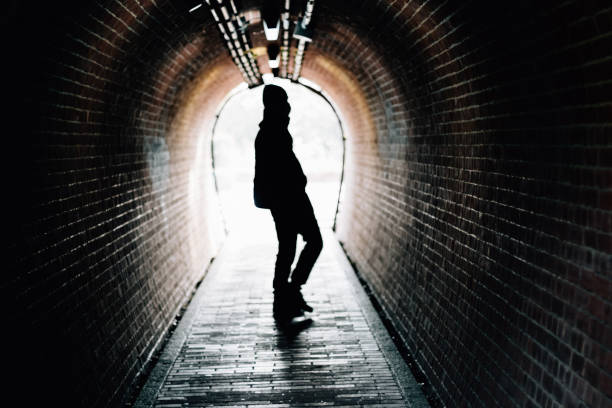 istock Silhouette of a man standing in a tunnel 1339193896