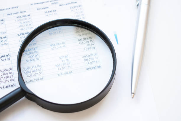 istock Conceptual Magnifying Glass on Top of Sales Invoice Reports, Emphasizing Scrutinizing Figures. 1339196067