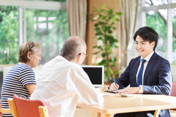 介護施設で老夫婦にアドバイスするビジネスマン - 介護　日本 ストックフォトと画像