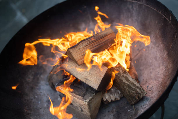 istock Outdoor chopped up logs burning fire in black metal fire pit 1339203178