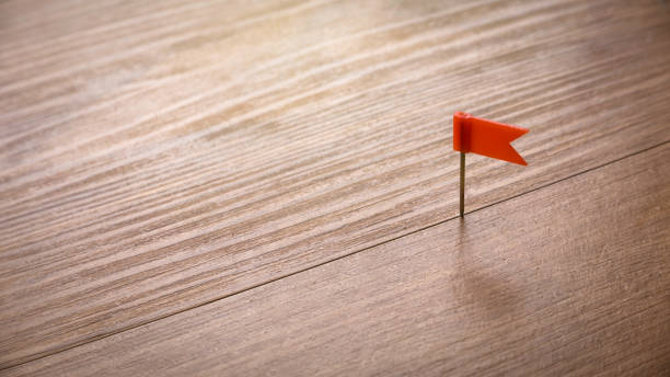 istock Red color flag pin isolated on a wooden background with copy space. 1339204285